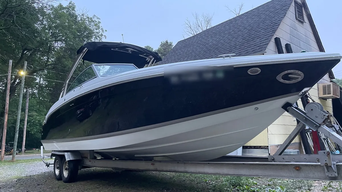 Glossy navy and white bowrider on its trailer after a detail